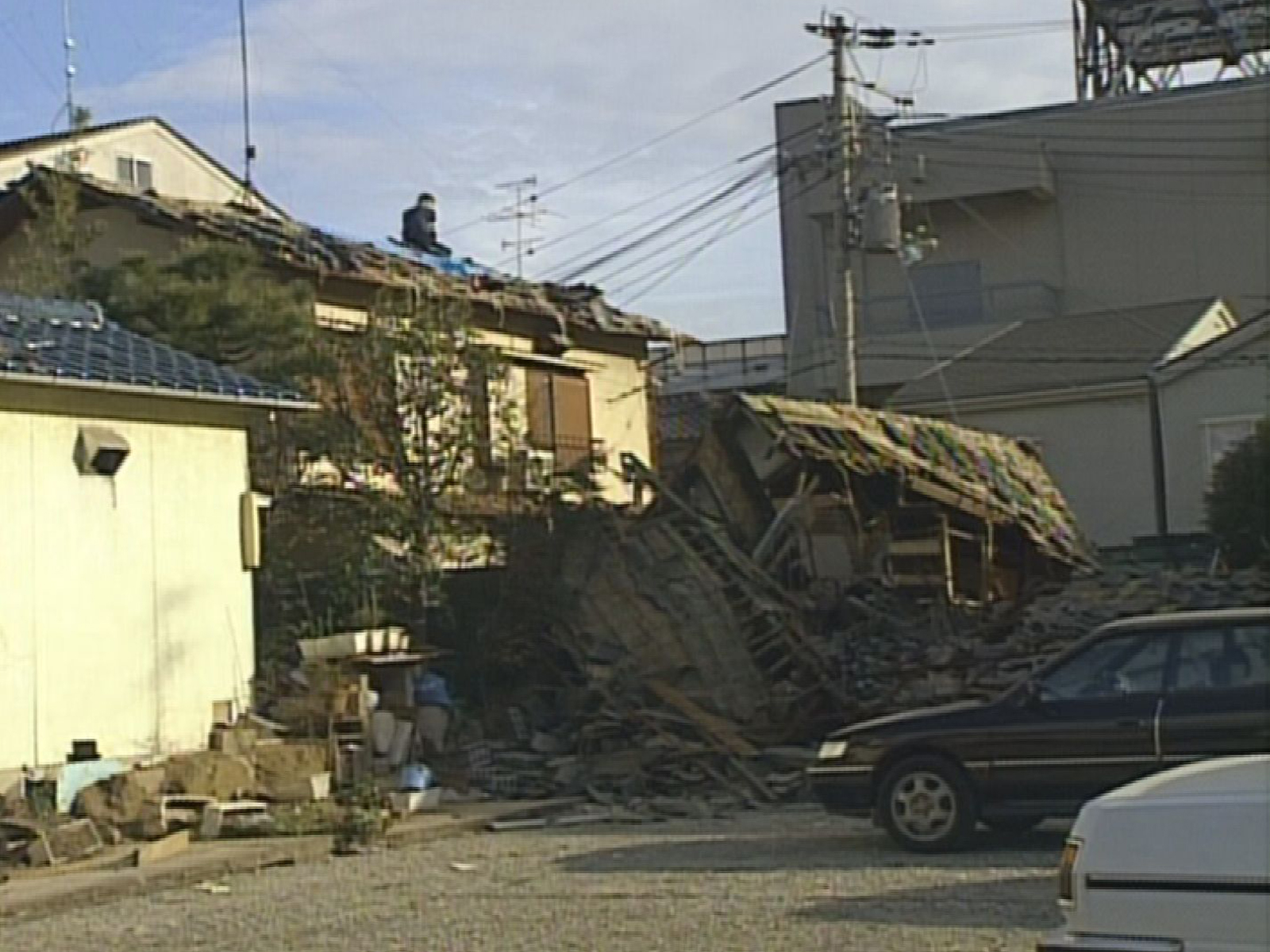 倒壊した住宅と、周囲に残された瓦礫の状況。